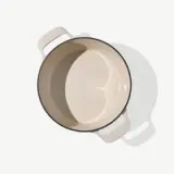 A beige-colored empty cooking pot with two handles is shown from above on a light background.