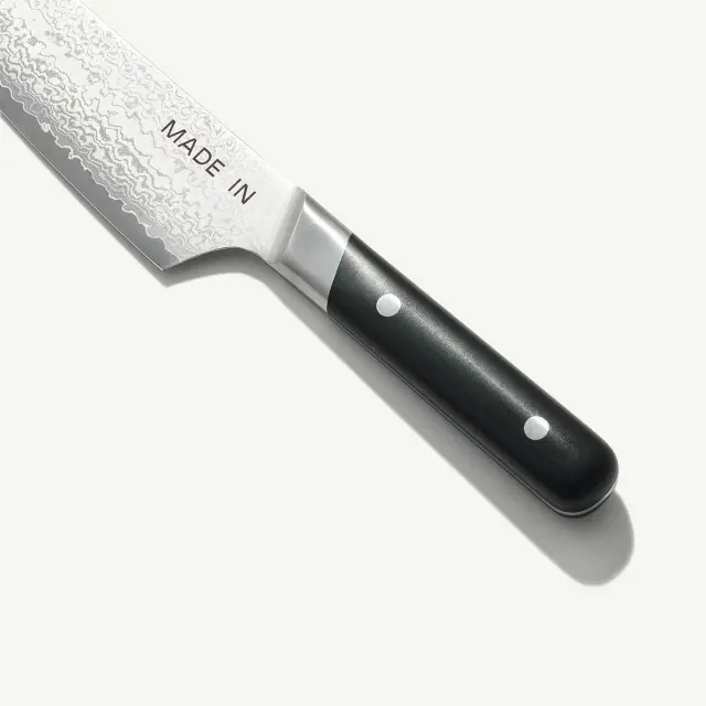 A chef's knife with a black handle and a blade inscribed with "MADE IN."