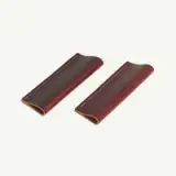 Two brown leather pen sleeves with visible stitching.
