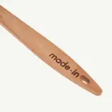 Wooden utensil with the text "made.in" engraved near the handle's hole.