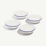 Four white bowls with blue rims are arranged in a group on a plain background.