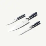 A set of three kitchen knives with dark handles and shiny blades, featuring a chef’s knife and two smaller utility knives.