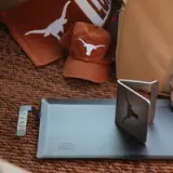 A collection of Texas Longhorns merchandise, including caps and a towel, accompanied by a laptop stand.