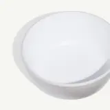 A smooth, round white bowl is shown on a neutral background.