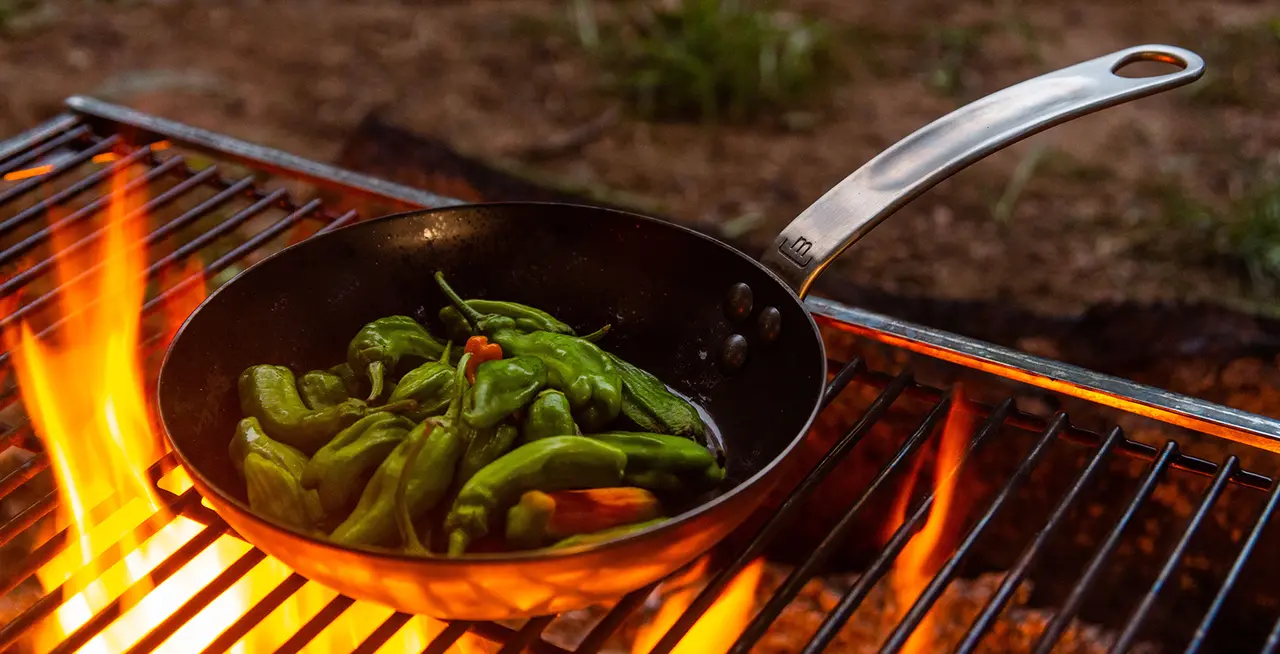 carbon steel pan with peppers on grill