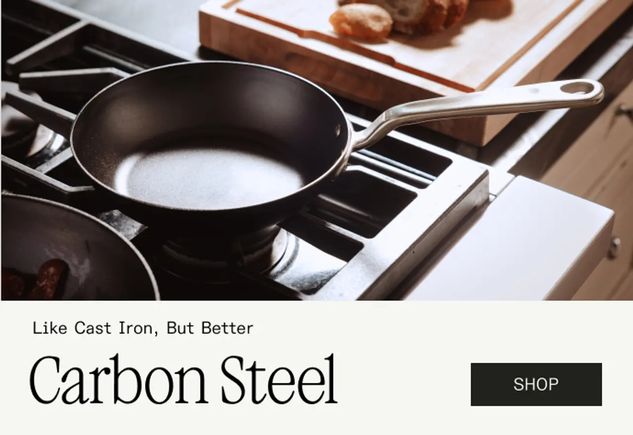 A carbon steel frying pan sits on a stovetop with other cookware in the background, promoting its benefits over cast iron.