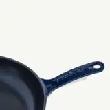 A dark blue cast iron skillet with the brand name "ModCrim" embossed on the handle.