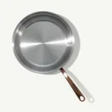 A stainless steel frying pan with a copper handle, shown from a top-down perspective.