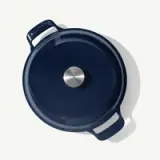 A deep blue cast iron pot with a stainless steel handle on the lid is shown from above.