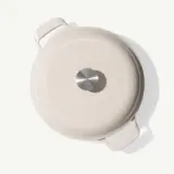 A round, light-colored cooking pot with a shiny stainless steel knob and handles.