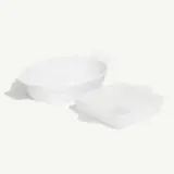 A set of two white baking dishes, one oval and the other square, placed on a light background.