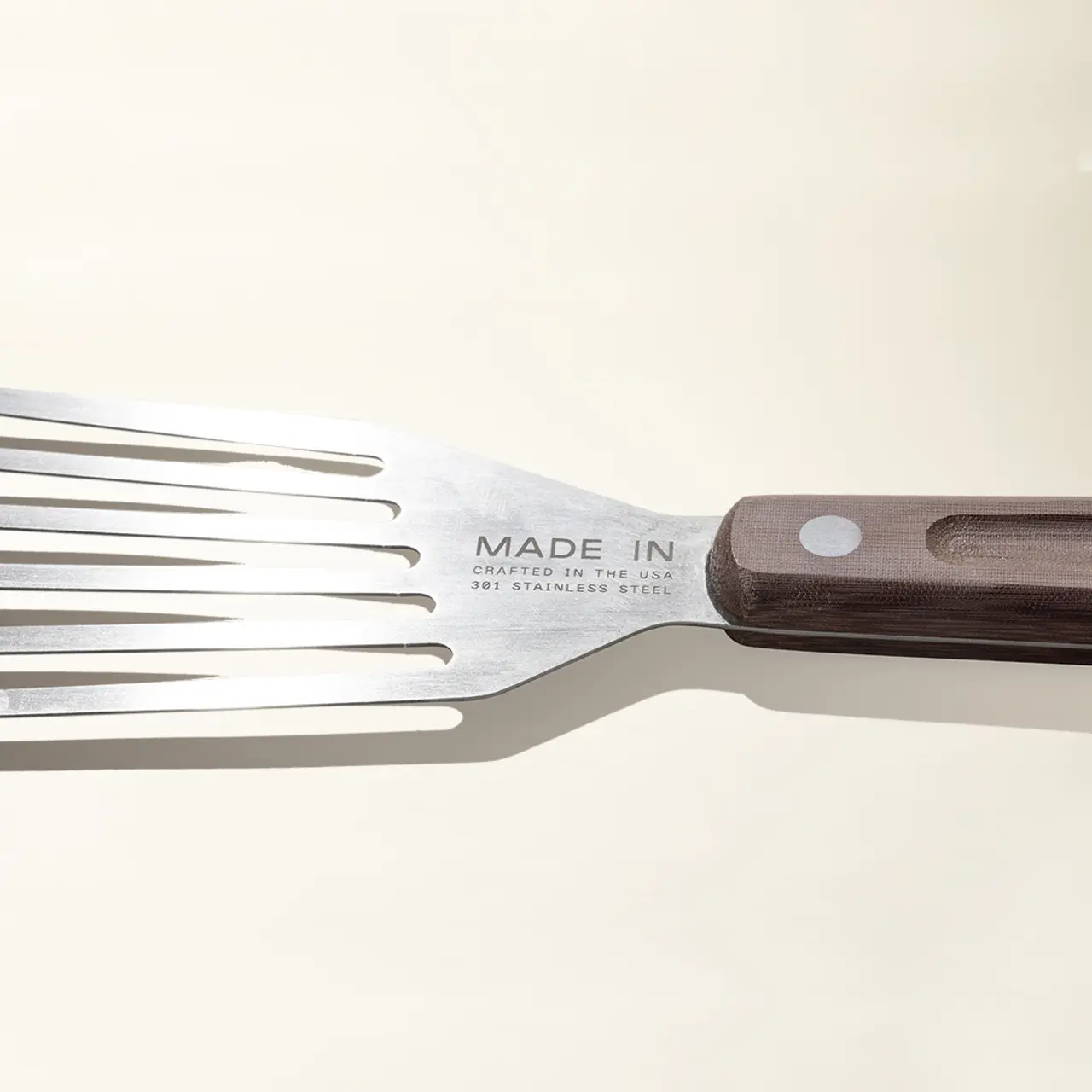 A close-up view of a fork with "MADE IN" text on the metal, indicating its place of origin.