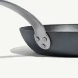 Close-up of a black frying pan with a silver handle.