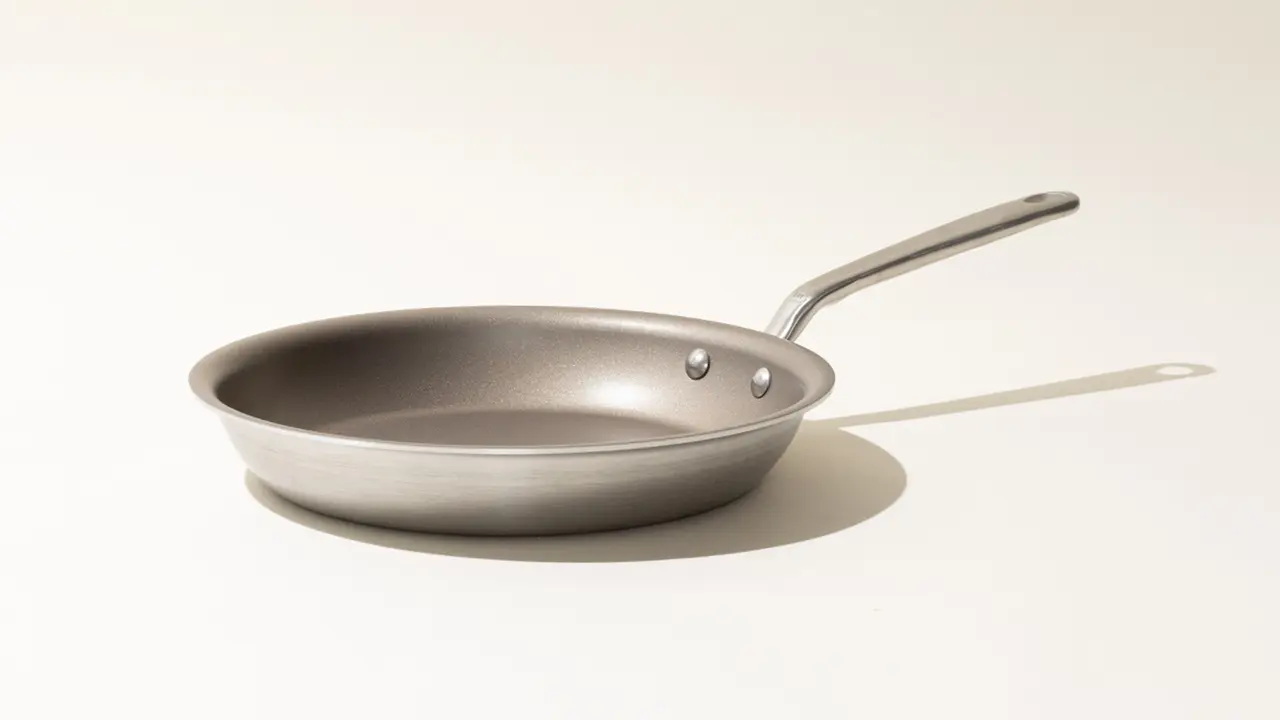 A single non-stick frying pan with a stainless steel handle on a light background.