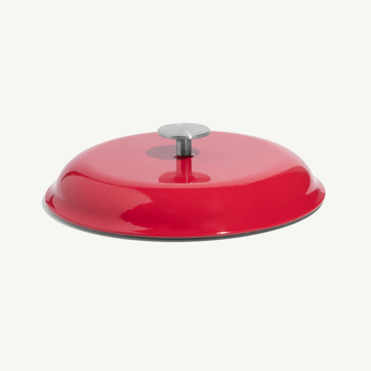 A bright red serving lid with a circular shape and a central handle.