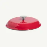 A bright red serving lid with a circular shape and a central handle.