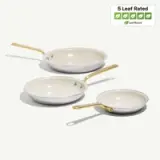 Three non-stick frying pans in varying sizes with light-colored interiors and gold handles, accompanied by a 5 Leaf Rated label indicating their eco-friendliness.