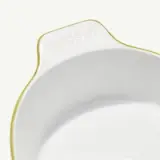 A close-up of a white ceramic bowl with a handle and the words "made in" embossed near the top edge.