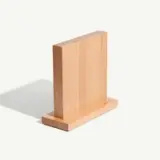 A wooden knife block stands upright on a plain background.