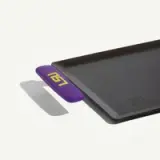 A flat, rectangular cooking griddle with a purple handle that features the text "LSU" in yellow.