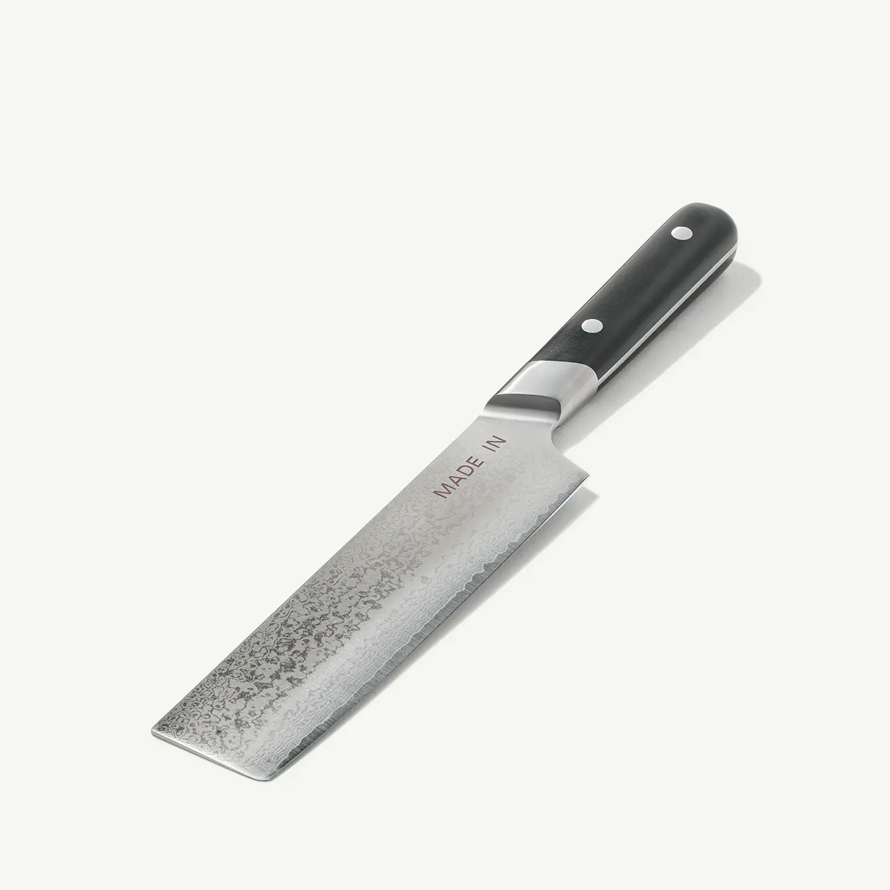 A kitchen knife with a dark handle and a broad, slightly textured blade marked "MADE IN."