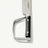 A close-up view of a cleaver with a black handle and the word "made-in" engraved on the blade.