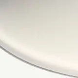 A close-up view of a blank, white plate with a small yellow stain near the bottom.