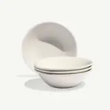 A stack of four white ceramic bowls is shown, with one bowl placed in the background.