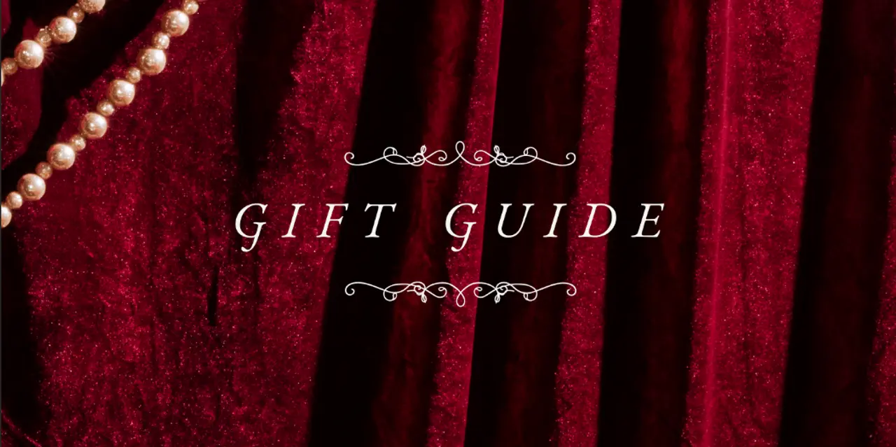 Luxurious red velvet background with a string of pearls and the words "GIFT GUIDE" in elegant script at the center.