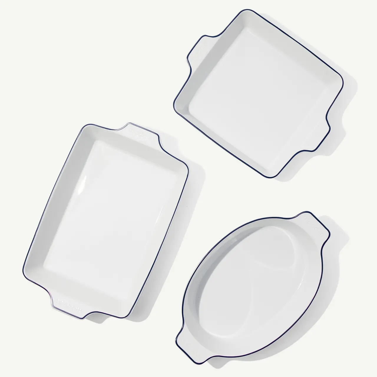 Three white serving dishes with different shapes are arranged on a light background.