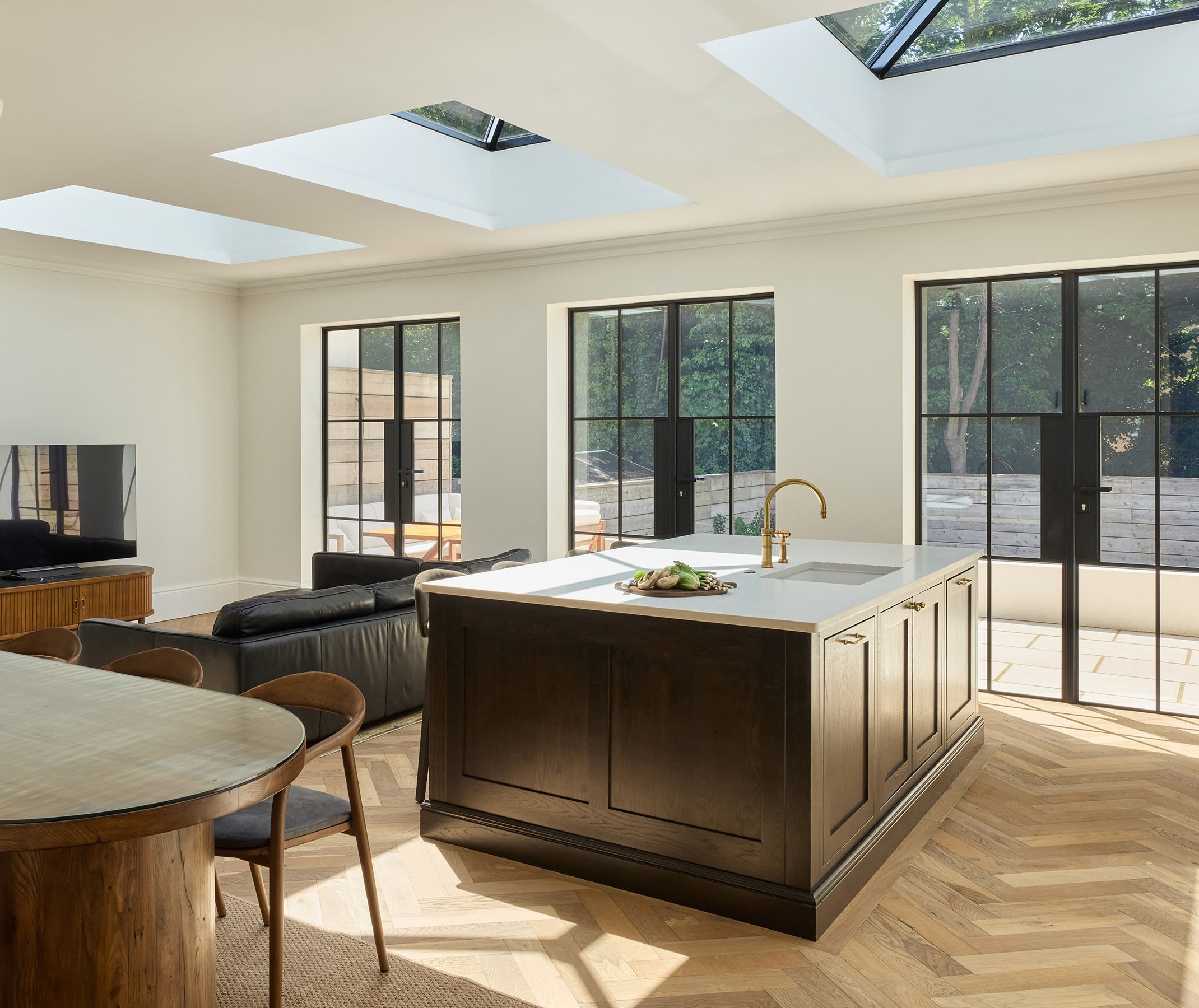 Herringbone wood floor in a light filled kitchen space