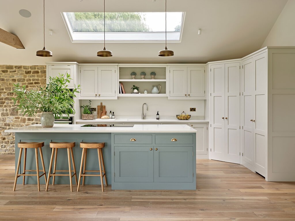 Interiors shot, white kitchen, blue island, wooden stools and Furrow plank wood floor