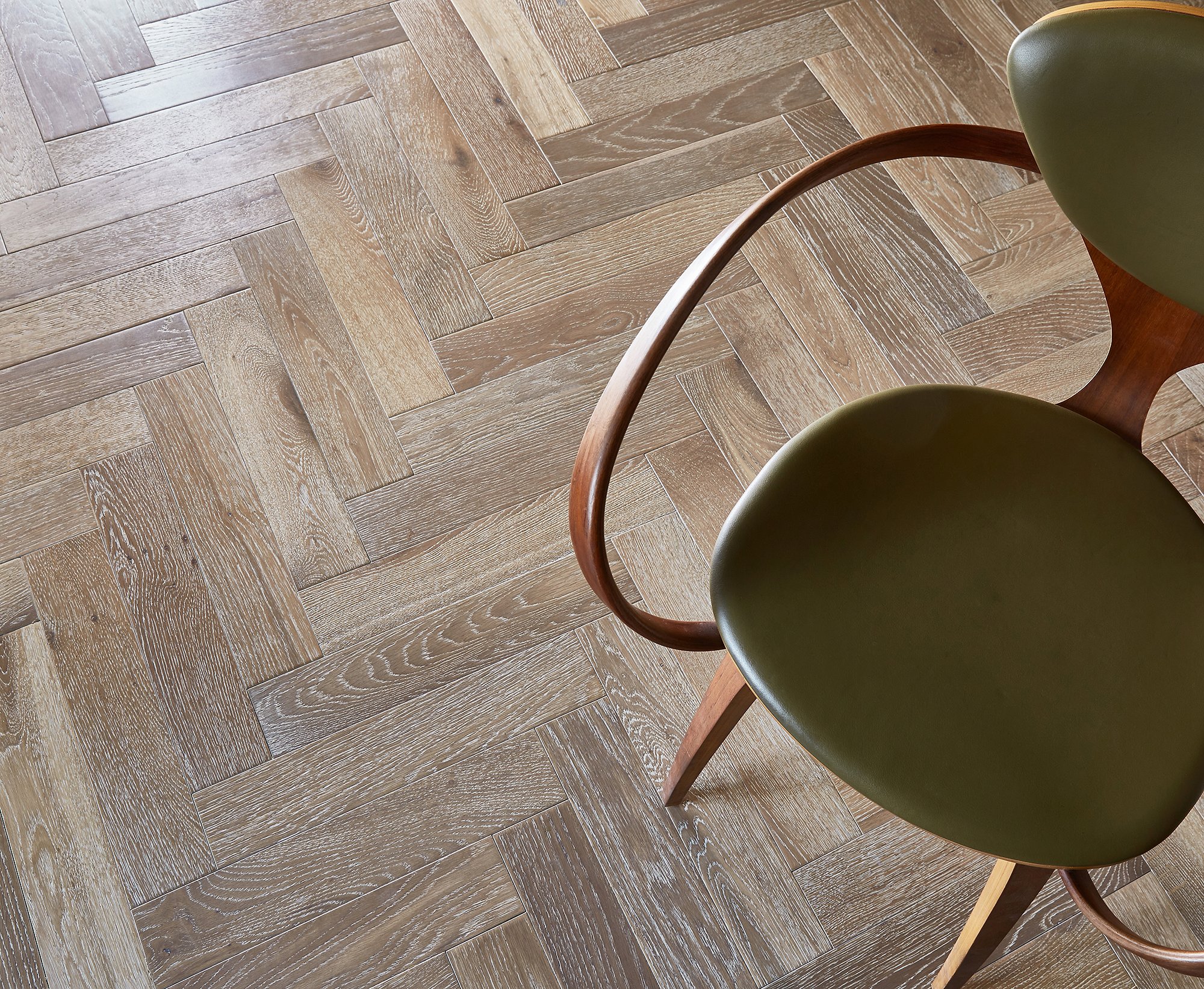 Crafted herringbone wood flooring with a chair