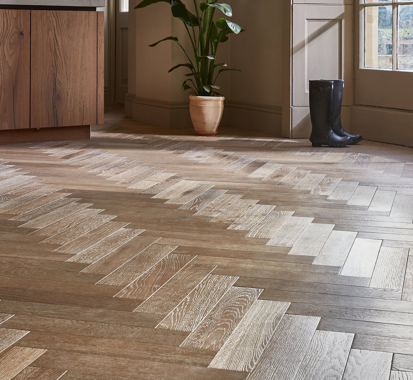 Close up of the herringbone wood flooring in a refined kitchen