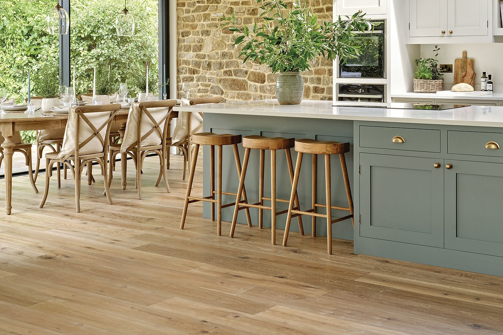 Plank wood flooring in a sunlit kitchen and dinning room