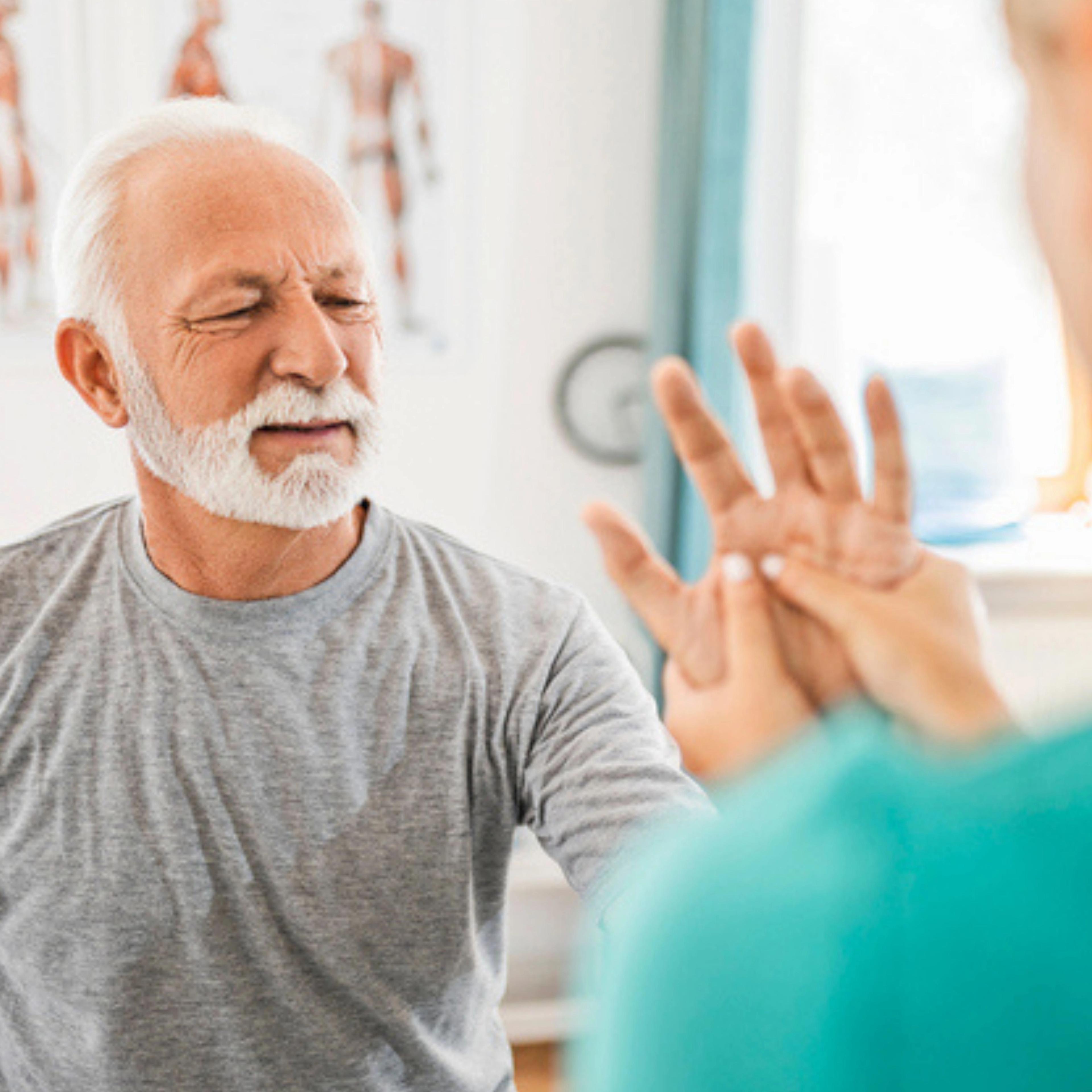 A HealthPro Heritage physical therapist guiding a patient through a strength exercise with a hand weight