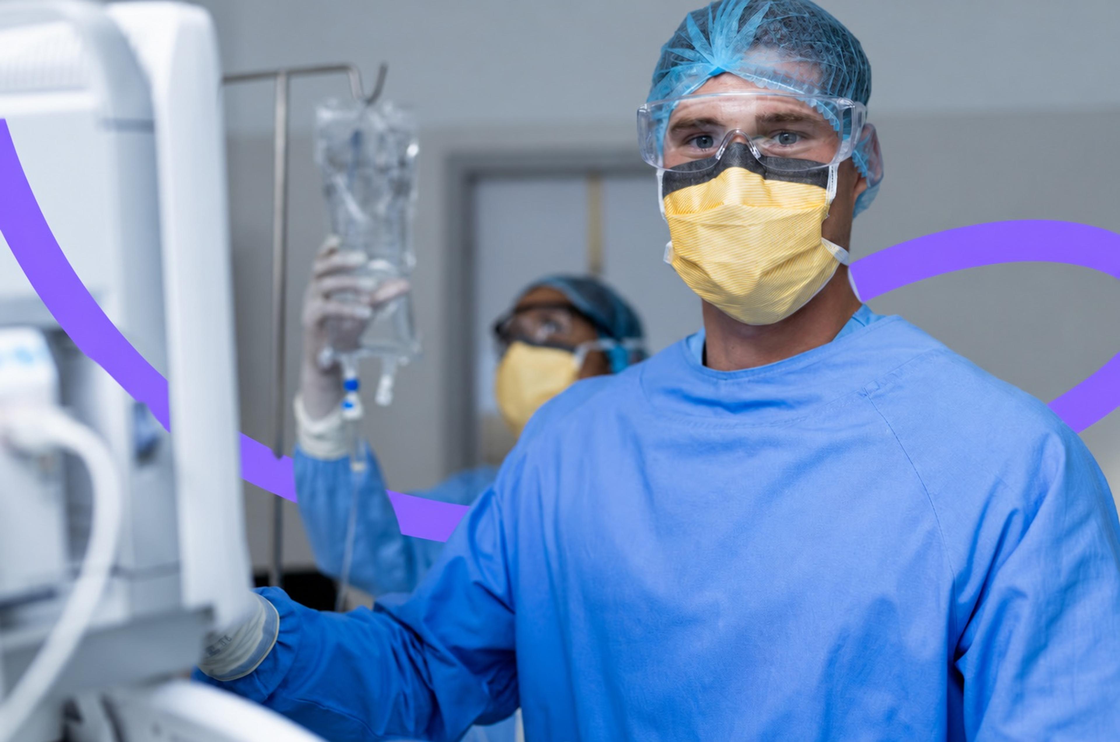 A nurse anesthetist in a surgical gown and mask adjusting an IV line in an operating room