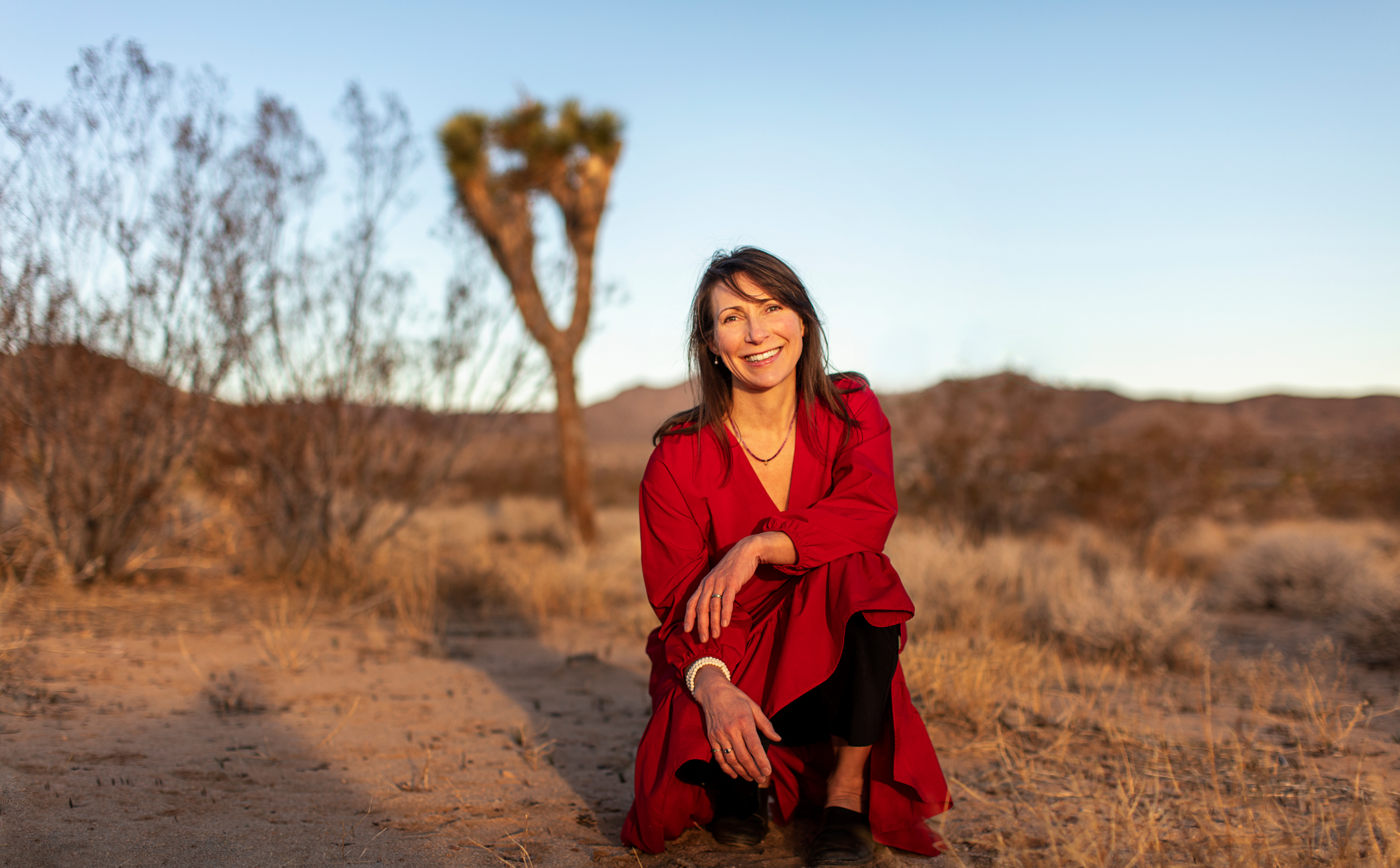 Karina Krepp standing in a desert wearing a red dress