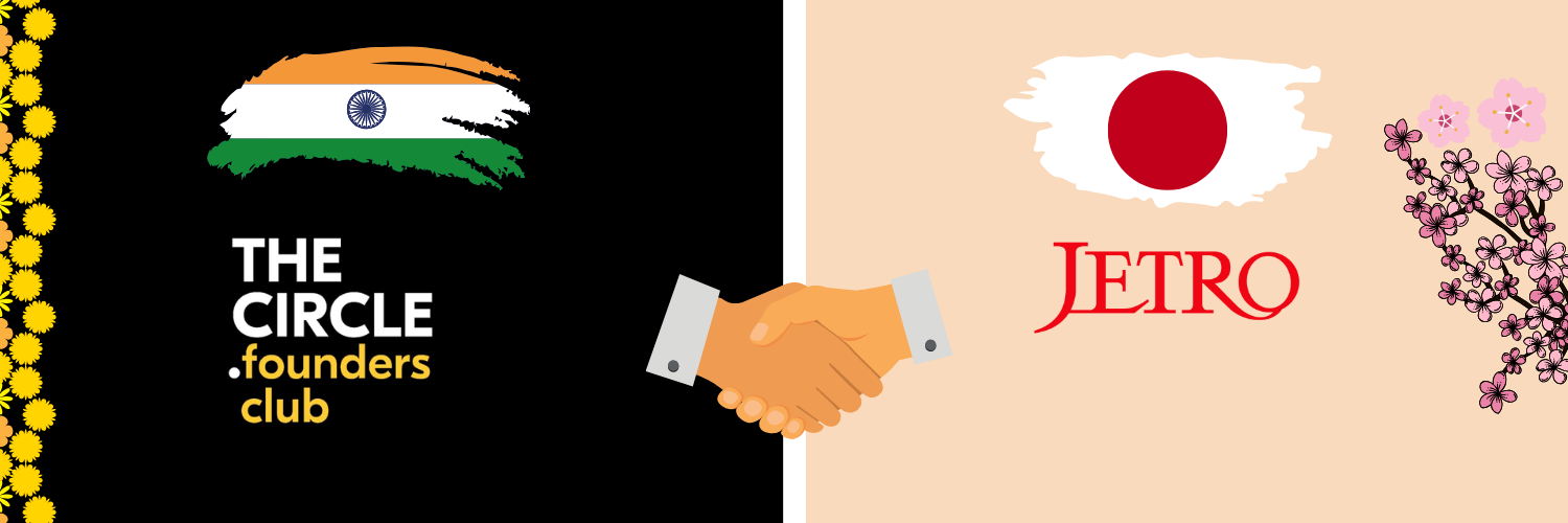 The image features a promotional banner representing the partnership between The Circle Founders Club and JETRO. On the left side, there's an illustration of the Indian flag followed by the text "The Circle Founders Club" decorated with a border of yellow flowers. The center of the banner shows a graphic of two hands shaking, symbolizing collaboration, set against a split background of black and cream. On the right side, the Japanese flag is illustrated with the name "JETRO" in red letters, complemented by a spray of pink cherry blossoms along the edge. The overall design highlights a cross-cultural partnership between India and Japan.