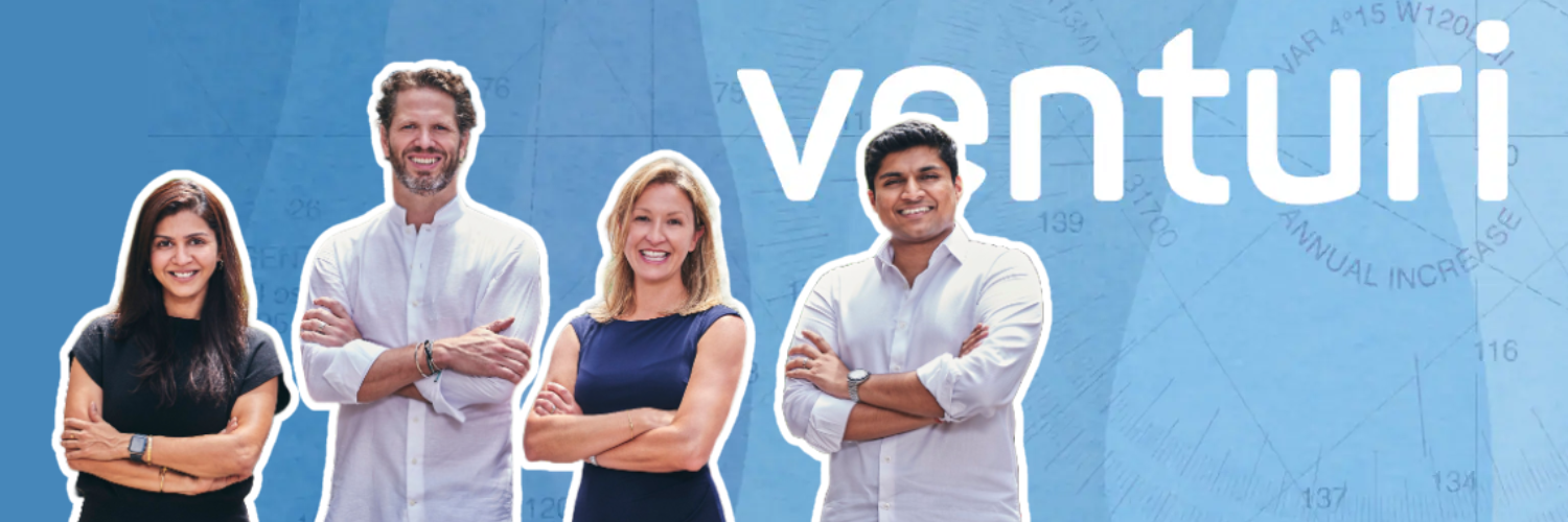 The image features a promotional banner for Venturi Partners. It shows four diverse professionals, two men and two women, standing confidently with their arms crossed in front of a large, light blue background that includes the word "Venturi" in bold white letters. Behind the text, there appears to be a blue graph or some form of data visualization. The individuals represent a multicultural team, suggesting an inclusive and global approach by Venturi Partners.