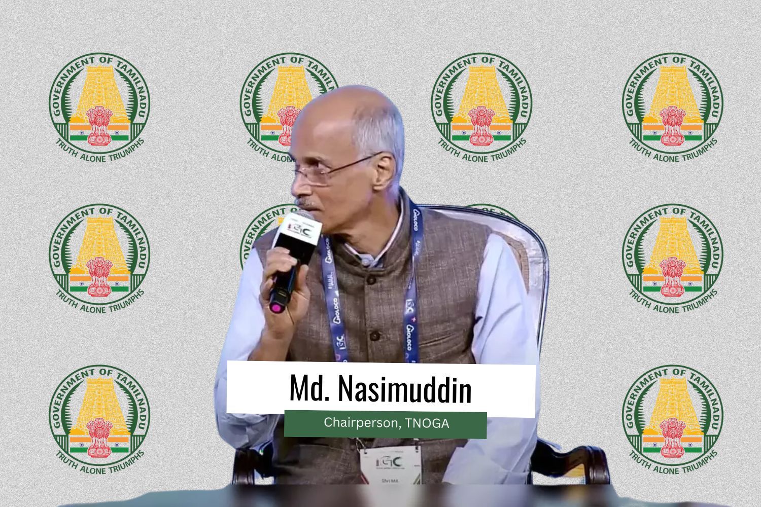 The image features Md. Nasimuddin, Chairperson of TNOGA, speaking into a microphone while seated on a stage. He is wearing a brown vest over a white shirt and has a conference lanyard around his neck. The background features multiple logos of the Government of Tamil Nadu, with the emblem and the phrase "Truth Alone Triumphs." A white and green text box at the bottom displays his name and title: "Md. Nasimuddin, Chairperson, TNOGA."