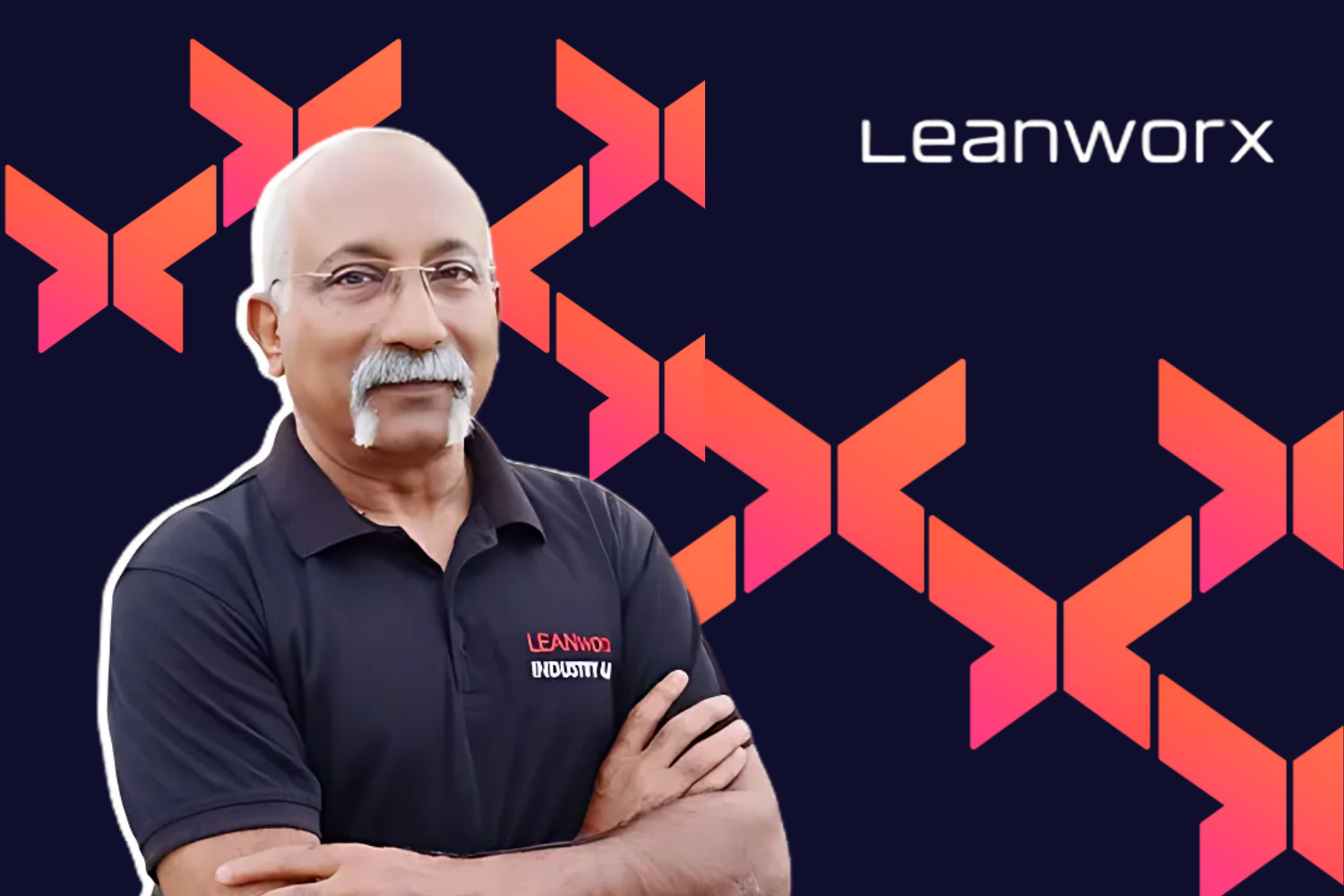A man with a mustache wearing a black polo shirt with the Leanworx logo, standing confidently with his arms crossed, against a dark blue background with abstract, geometric patterns in pink and orange. The Leanworx logo is displayed in the upper-right corner.