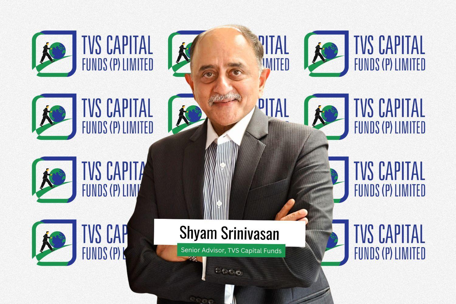 Shyam Srinivasan, newly appointed Senior Advisor at TVS Capital Funds, stands confidently in a suit with arms crossed, smiling against a backdrop featuring multiple TVS Capital Funds (P) Limited logos.