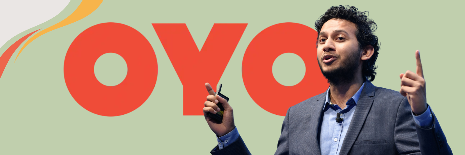 The image features Ritesh Agarwal, the founder of OYO, standing on a stage and speaking passionately with his right hand raised and holding a marker. The backdrop includes a large, stylized OYO logo in red with a flowing yellow and orange design, set against a light green background. Ritesh is dressed in a dark suit with a light blue shirt, looking engaged and dynamic as he addresses his audience.