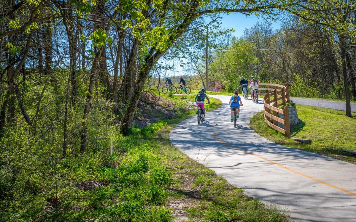 Family with kids biking on bike trail