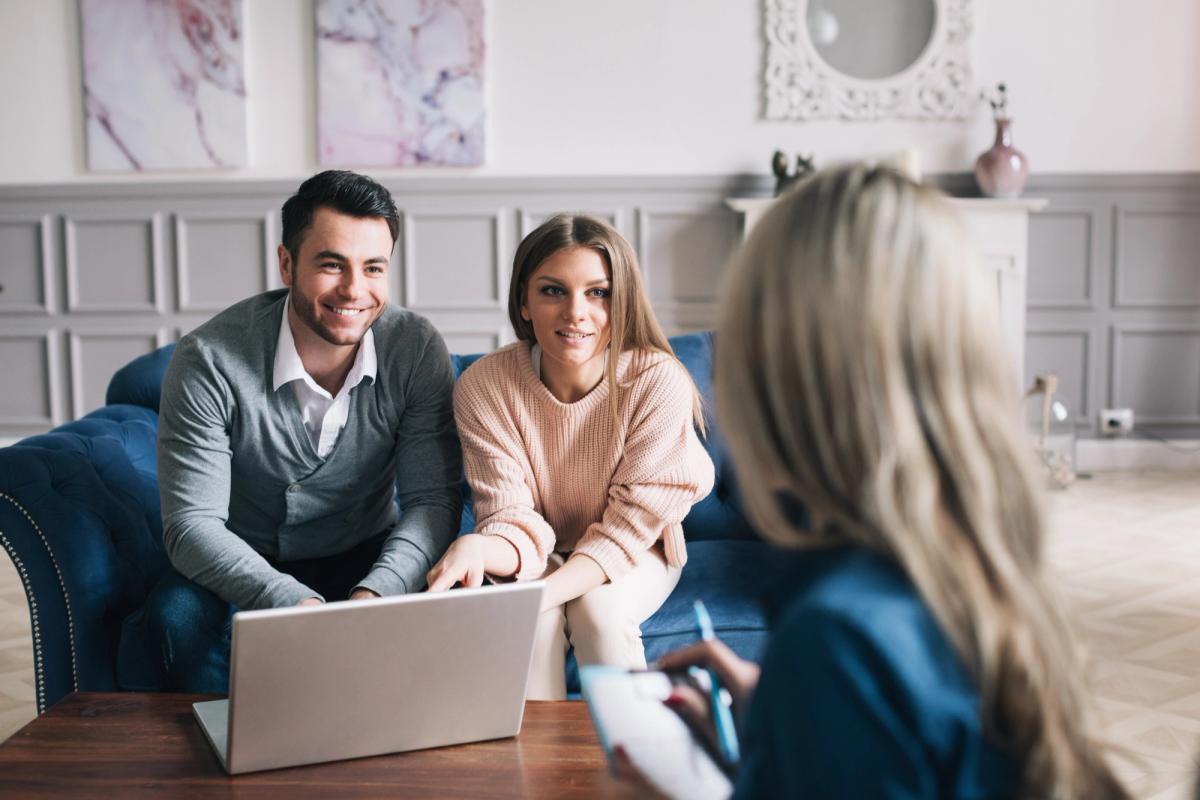 Real-estate agent shows a build project to a young couple.