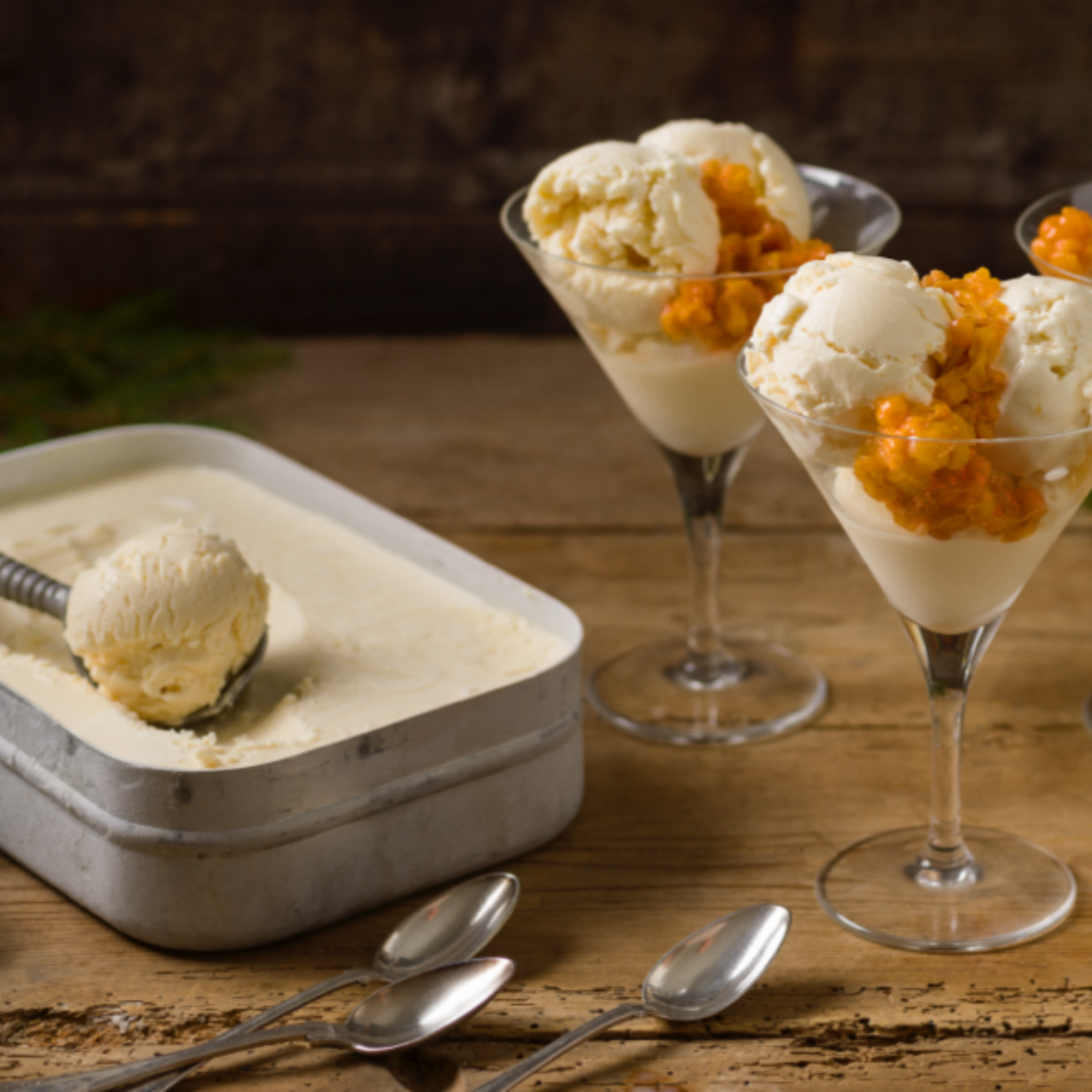 Krämig hemmagjord glass med Messmör Citron serverad i glas och toppad med varma hjortron.