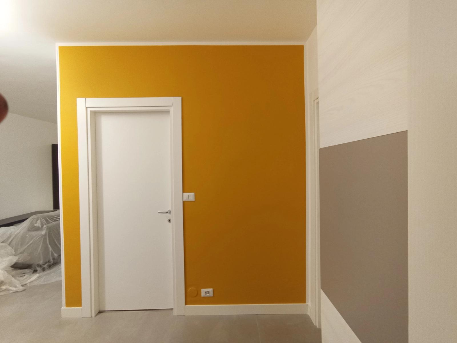 Tinteggiatura interni con parete arancione e decorazioni moderne