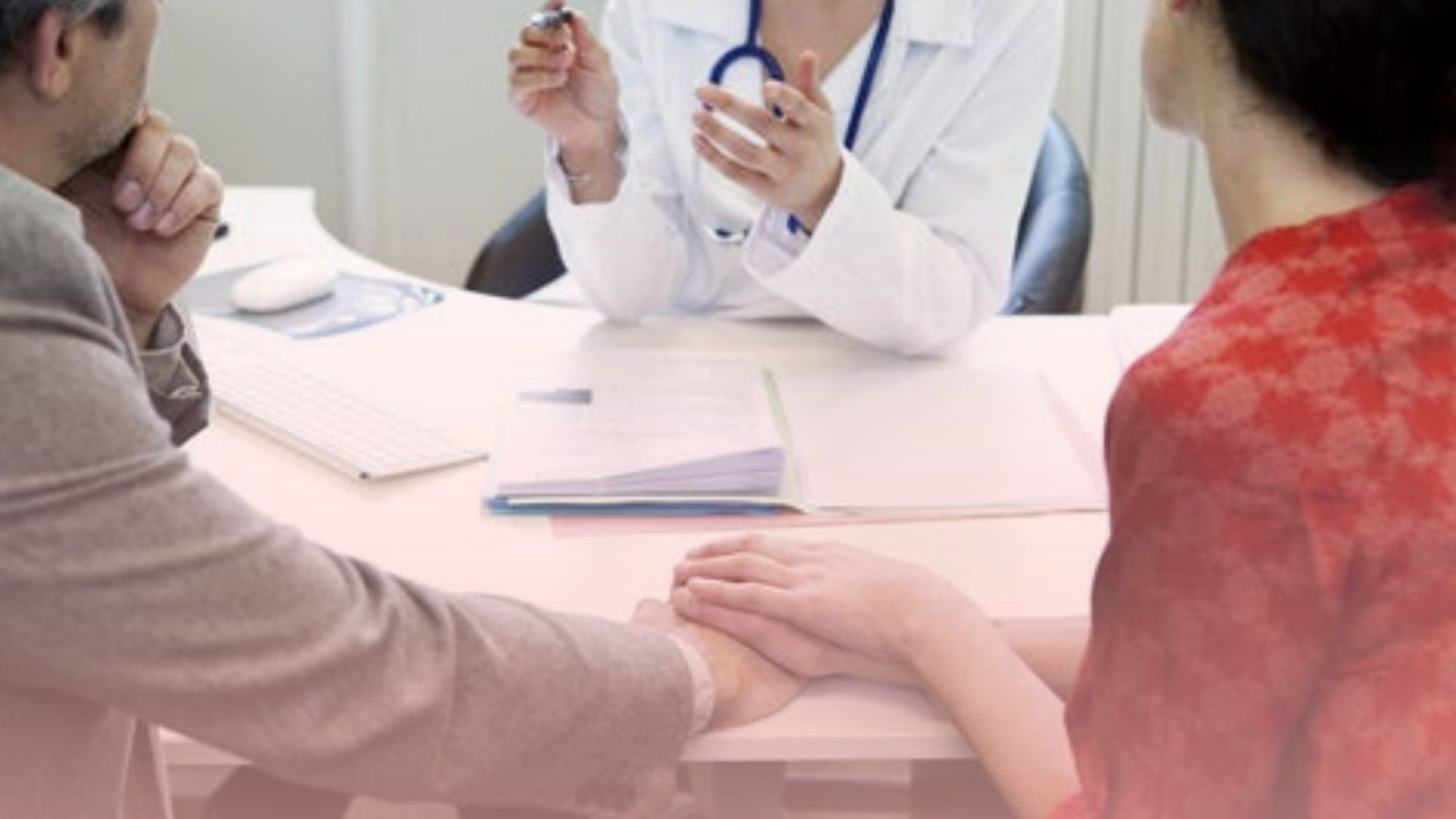 Pareja sosteniéndose de las manos mientras consulta con un especialista médico, reflejando la privacidad y empatía de nuestro servicio de sexología.