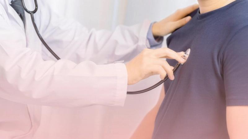 Médico especialista con bata blanca examinando el corazón de un paciente usando un estetoscopio sobre su pecho. Una imagen que refleja la empatía, el cuidado y la precisión clínica durante la consulta de rutina con nuestro cardiólogo